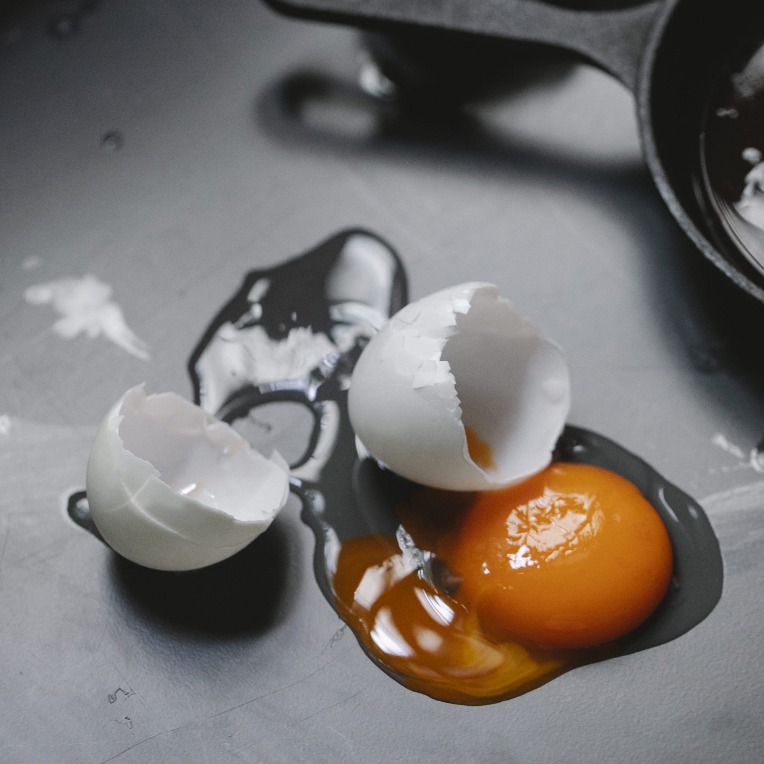 Broken egg scattered on table in kitchen