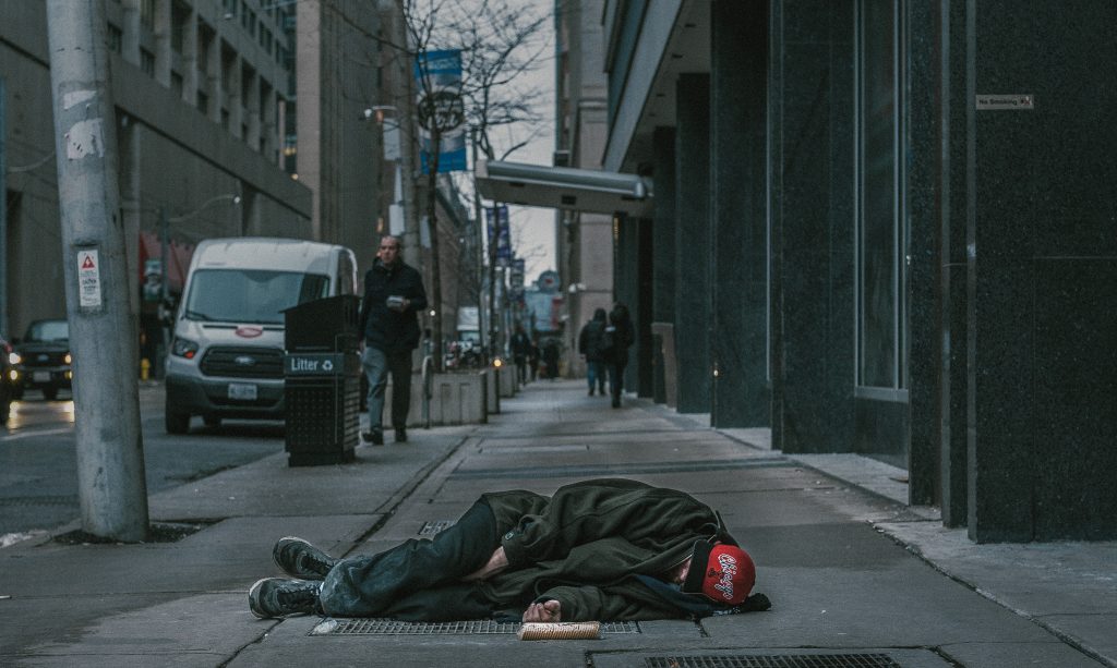 Photo of man laying on sidewalk